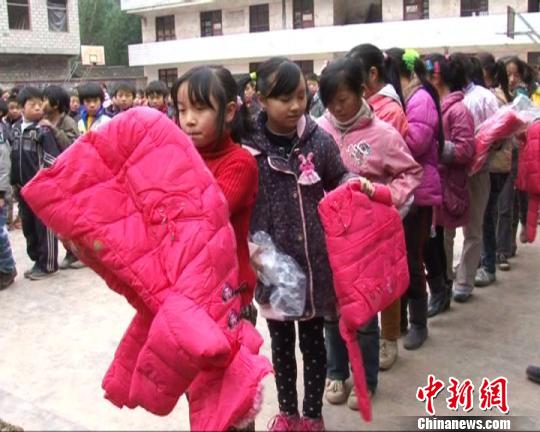 图为云南大关县的贫困儿童正在穿港惩教社教育基金会捐赠的新衣。 肖恒英 摄