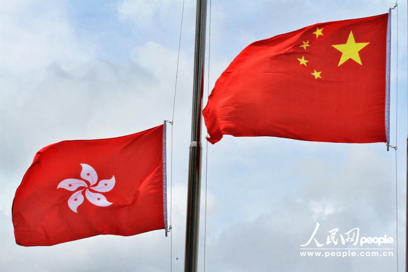 冉冉升起的五星红旗与香港区旗.摄影: a href=