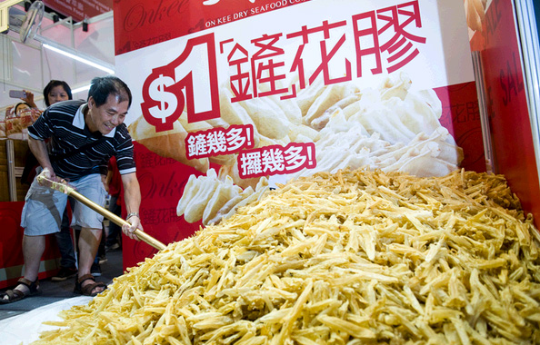 香港市民一早排队抢十个名额，用铲子大铲安记海味“$1铲花胶”。哇哦，一块钱铲一堆噢~~