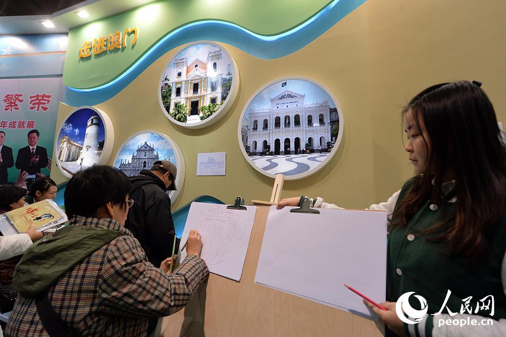 12月12日，市民参观澳门特别行政区成立15周年成就展。（人民网记者 翁奇羽 摄）