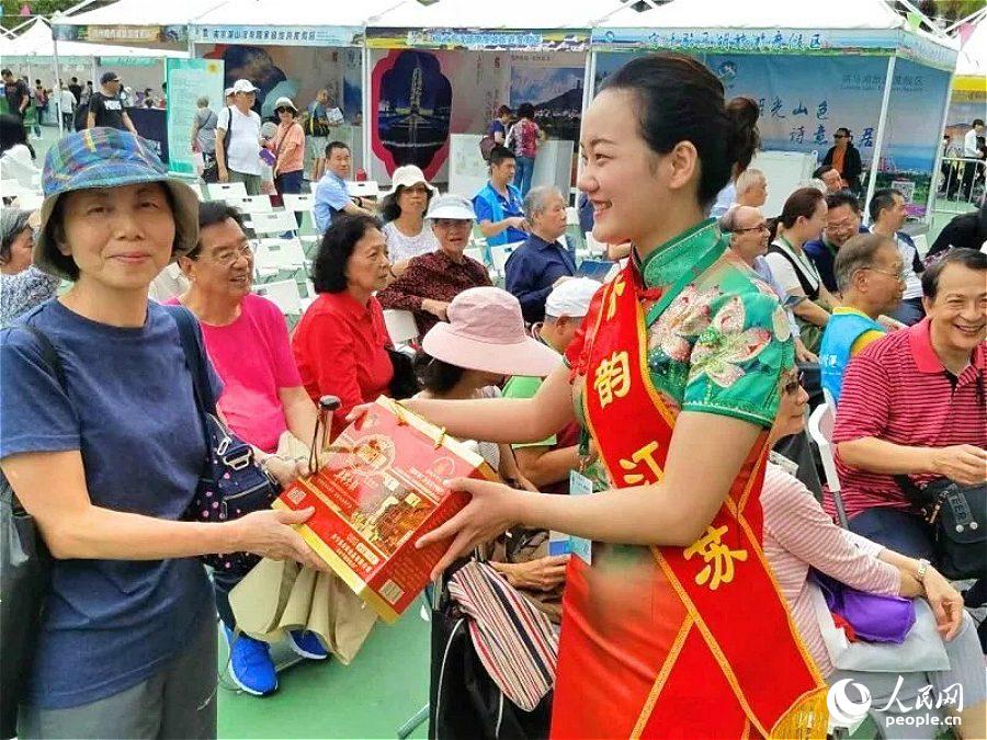 旅游推介员向香港市民赠送盐城旅游纪念品。