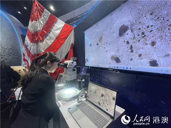 图为观众通过显微镜观看月壤。人民网记者富子梅摄