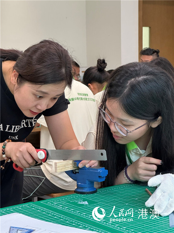 图为教养真挚全心考验同学们学习制作鲁班锁。（本报记者富子梅摄）