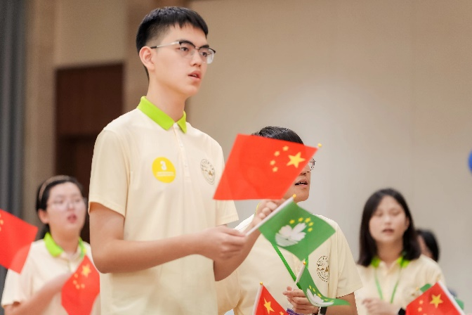 图为同学们在联欢会上挥舞国旗区旗唱响《我和我的祖国》。主办方供图