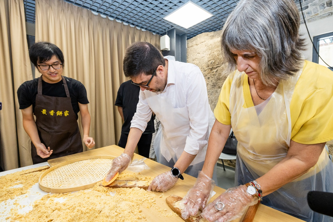 图为代表团体验非物质文化遗产项目杏仁饼制作技艺线上实盘配资。主办方供图