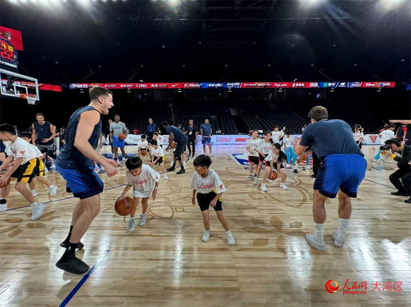 图为镜平学校和鲍思高粤华小学的同学们在美职篮（NBA）球员指导下传球。人民网记者 富子梅摄