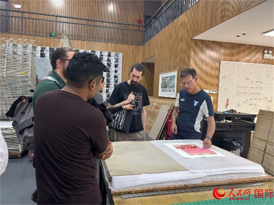 10月20日，在深圳观澜版画原创产业基地，版画艺术家正在展示版画创作过程。人民网 高文潇摄