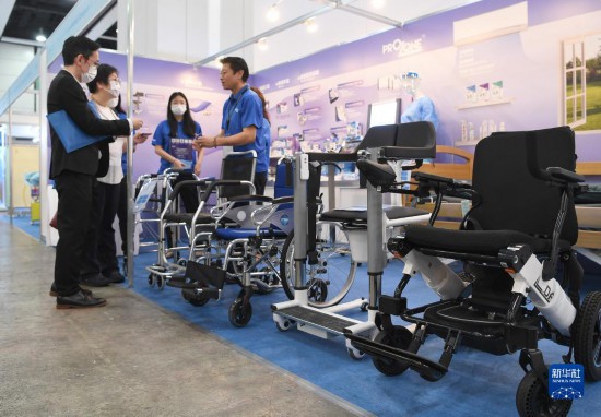 5月16日，参展商在第十四届“香港国际医疗及保健展”上介绍轮椅和升降转移椅。新华社记者 陈铎 摄