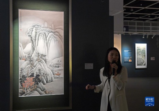 11月24日，在香港会议展览中心，导赏员讲解张大千作品《关山密雪图》。新华社记者 陈铎 摄