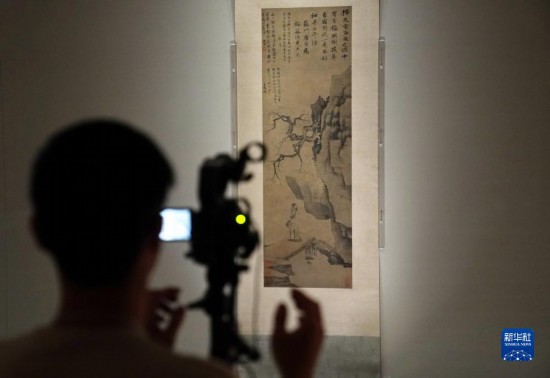 12月12日，邪在喷鼻港故宫文明专物馆，忘者邪在拍摄唐寅的《观梅图》。新华网忘者 王申 摄
