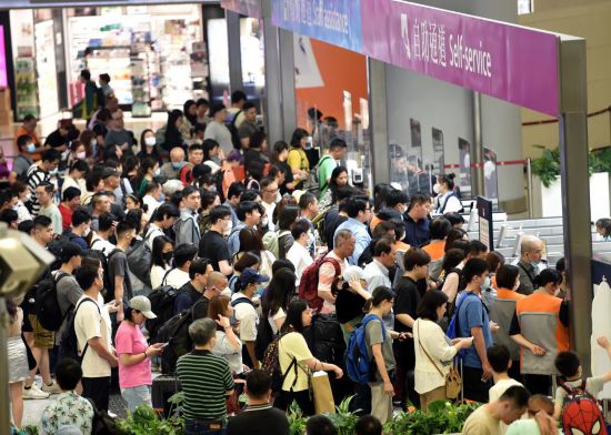 图为3月30日，香港市民在西九龙高铁站出行。3月29日起，香港开启长入四天的回生节小长假，<a href=