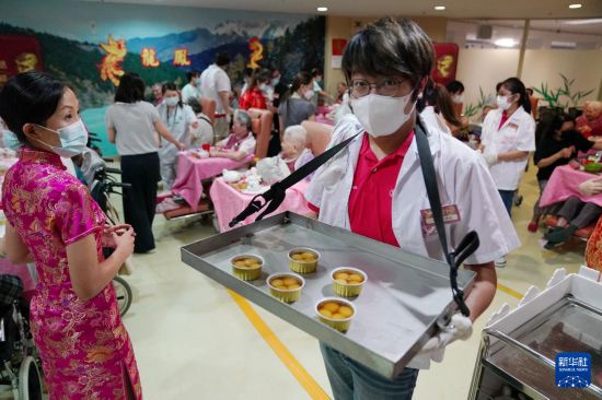 5月24日，在香港松悦园耆和护养院，身穿白衫的伙计在“茶楼”售卖茶点，端茶倒水。新华社发（王申 摄）