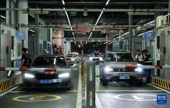 12月23日零时，“粤车南下”入境香港市区的首批通关车主在“一站式”通道办理通关手续。新华社记者 黄国保 摄