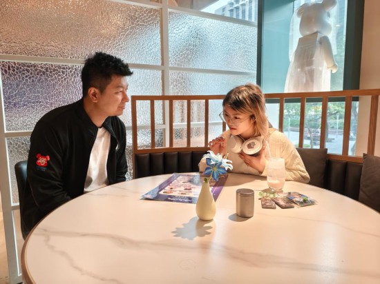 　　11月24日，刘承铭（左）在餐厅与食客交谈。刘承铭在香港尖东经营一家咖啡简餐厅，从2024年夏天开始承办游戏与动漫IP主题餐厅活动。新华社记者 刘英伦 摄