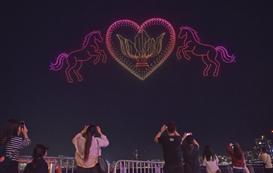 2月14日,人们在香港湾仔海滨观看、拍摄无人机表演。新华社记者 陈铎 摄