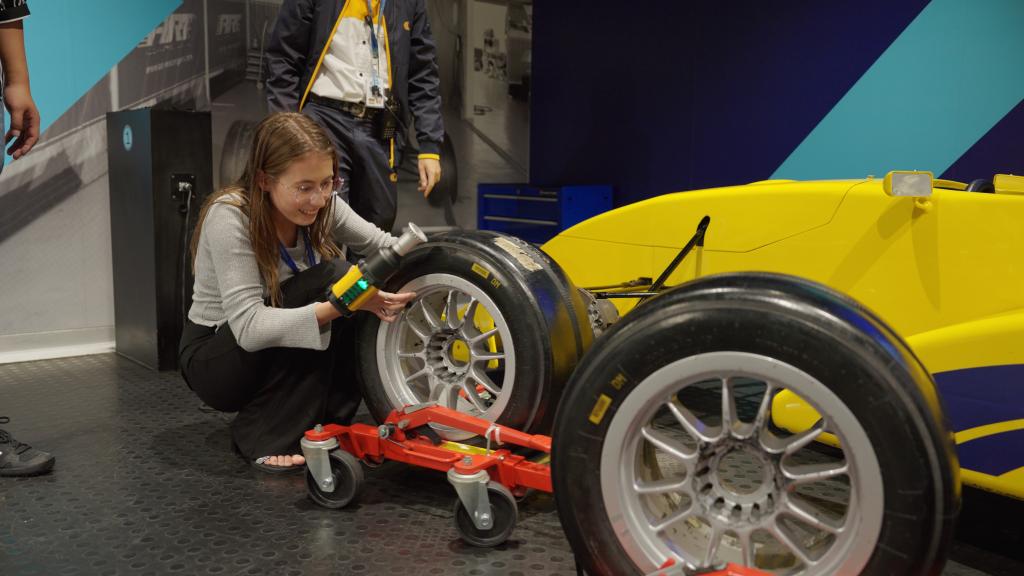 12月16日，参访团成员卡丽娜体验给赛车更换轮胎。新华网领